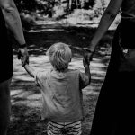 Kind loopt hand in hand met ouders
