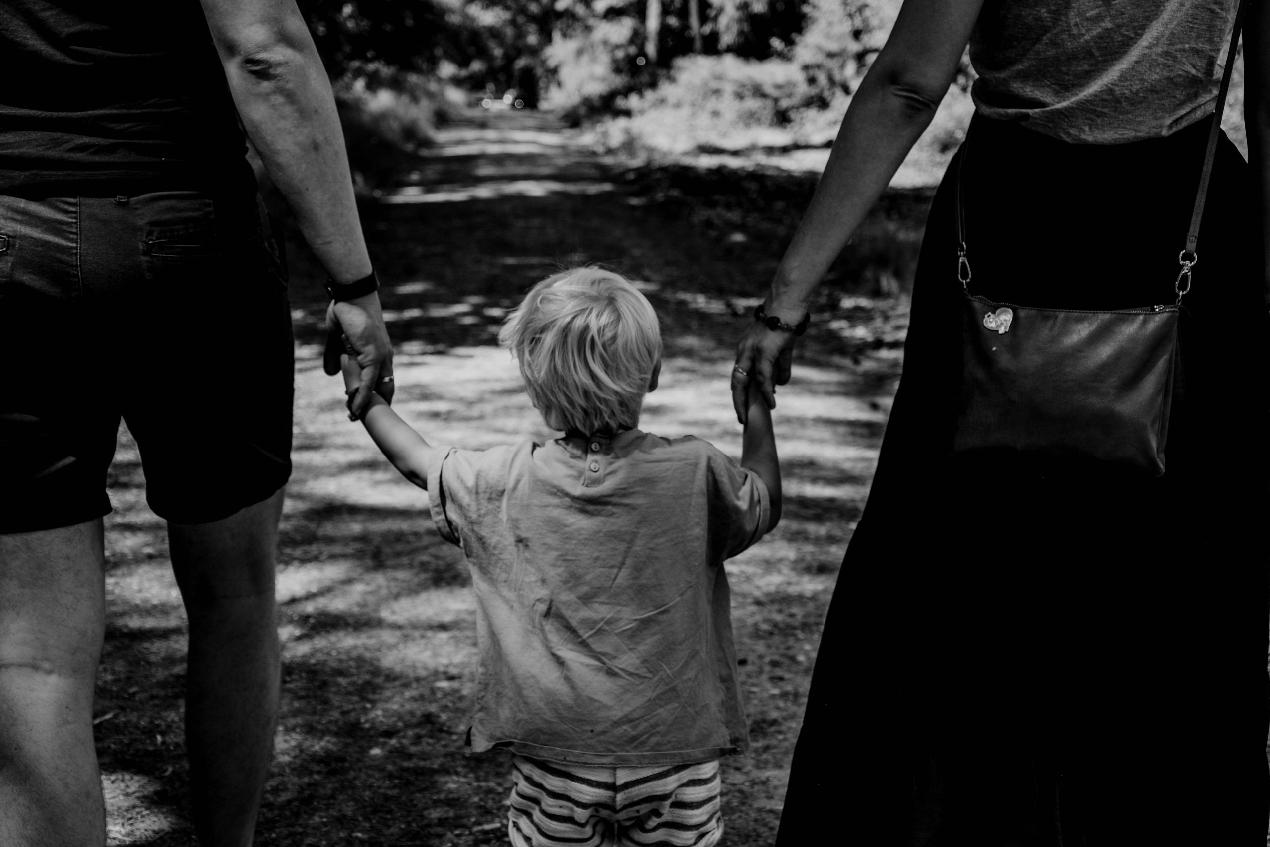 Kind loopt hand in hand met ouders